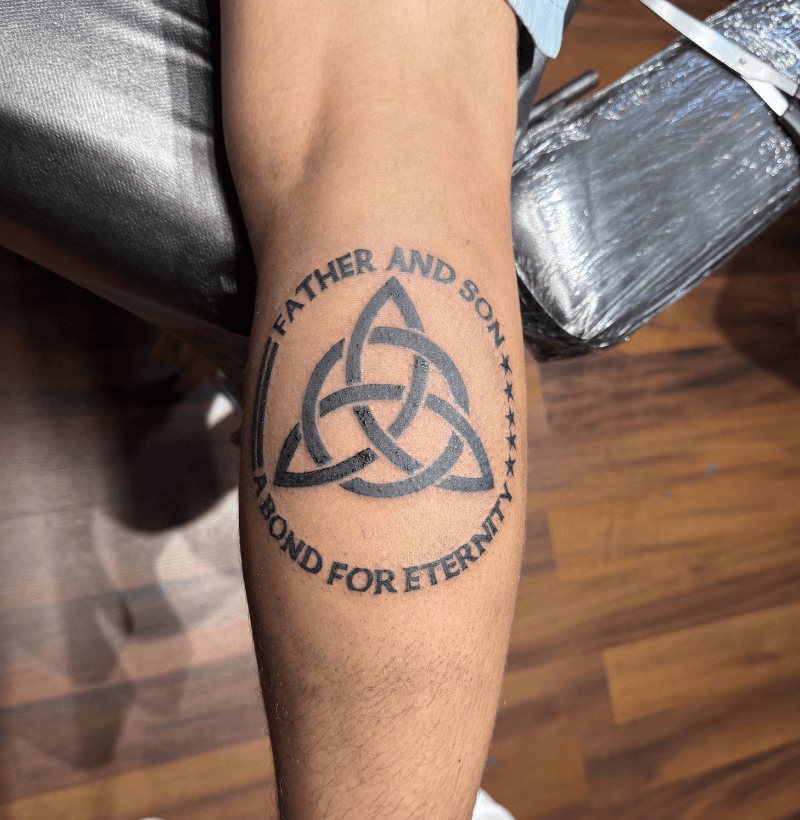 Father and son tattoo featuring a Celtic trinity knot with the words “A Bond for Eternity,” done at Bullett’s Ink in Mount Airy, Maryland.