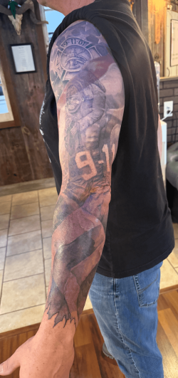 9/11 firefighter memorial tattoo sleeve featuring a detailed firefighter design, American flag, and tribute elements, created at Bullett’s Ink in Mount Airy, Maryland.