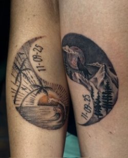 Matching black and white tattoos featuring a beach sunset on one arm and a mountain landscape with a wolf on the other, both with the same date.