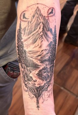 Black and grey mountain landscape tattoo with trees, river, and moon by Robyn at Bullet’s Ink in Mount Airy MD